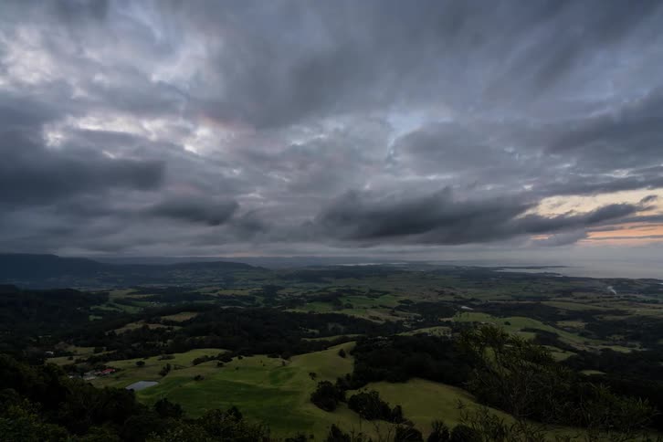Clouds pass over a vast green plain