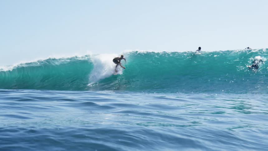 Man surfs a wave with a surfboard in the ocean