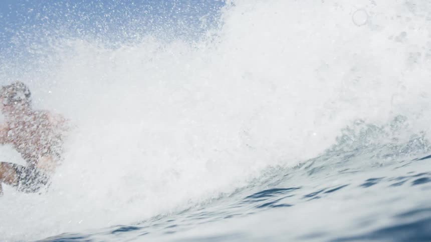 A tall wave knocks a surfer underwater