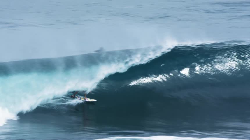 Several people surfing and body surfing in the water as one male flies off his board after hitting a big wave