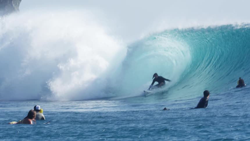 Surfer rides an ocean wave on a surfboard