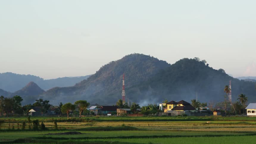 Buildings in a rural area in front of hills