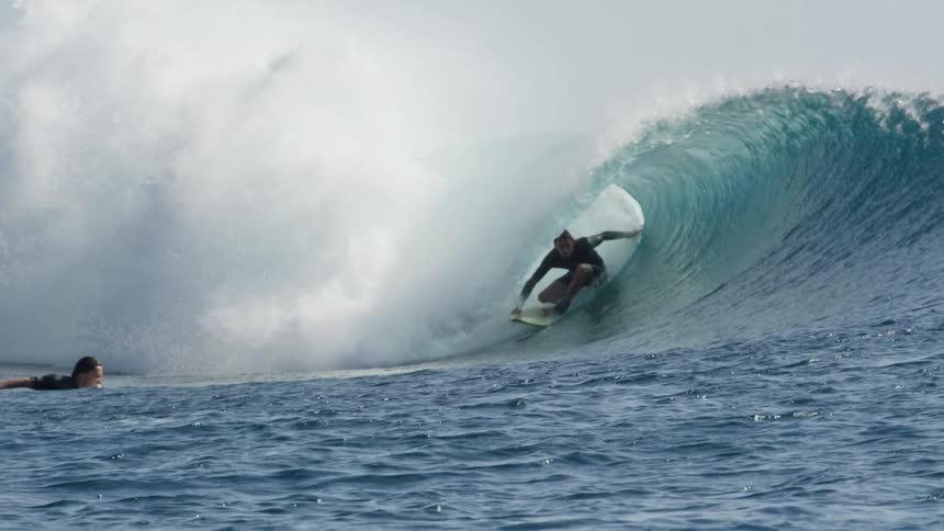 Surfer surfing through a tube wave in the ocean