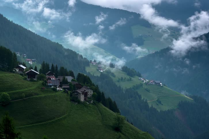 Buildings of a rural village cling to the slope of a steep mountain