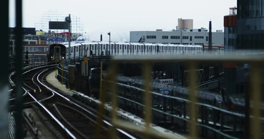 A train rolls along a track in a large city