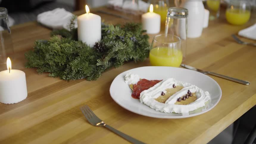 A pancake made to look like Santa sits on a plate on a table