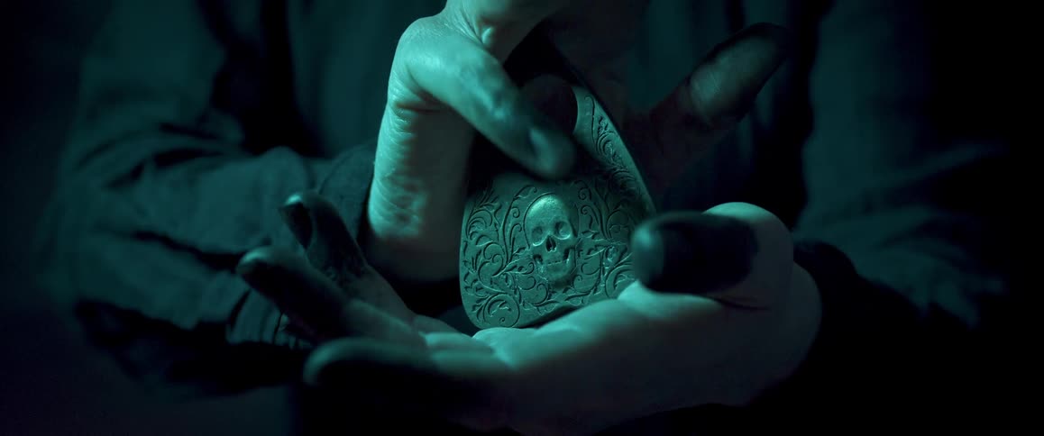 A person clasps a pointer for an ouija board