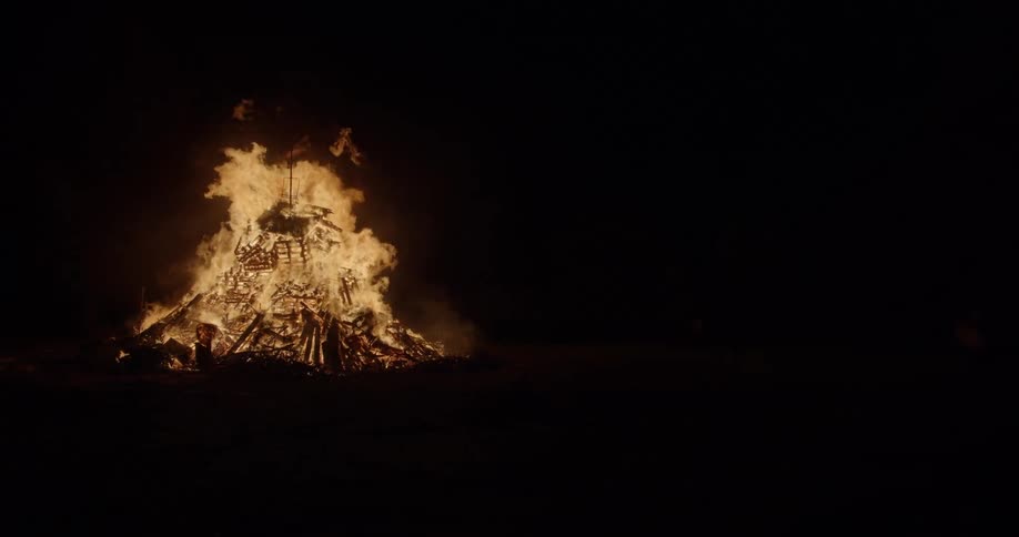 A large fire burning outside at night