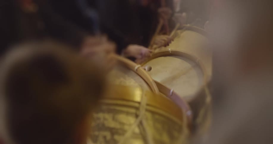 People with drumsticks beating on drums