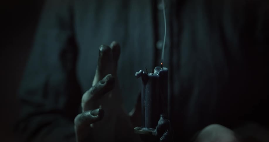 A person moves their hand around a smoking candle