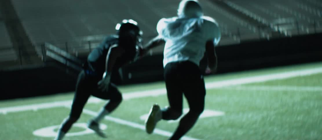 Two football players running down a field