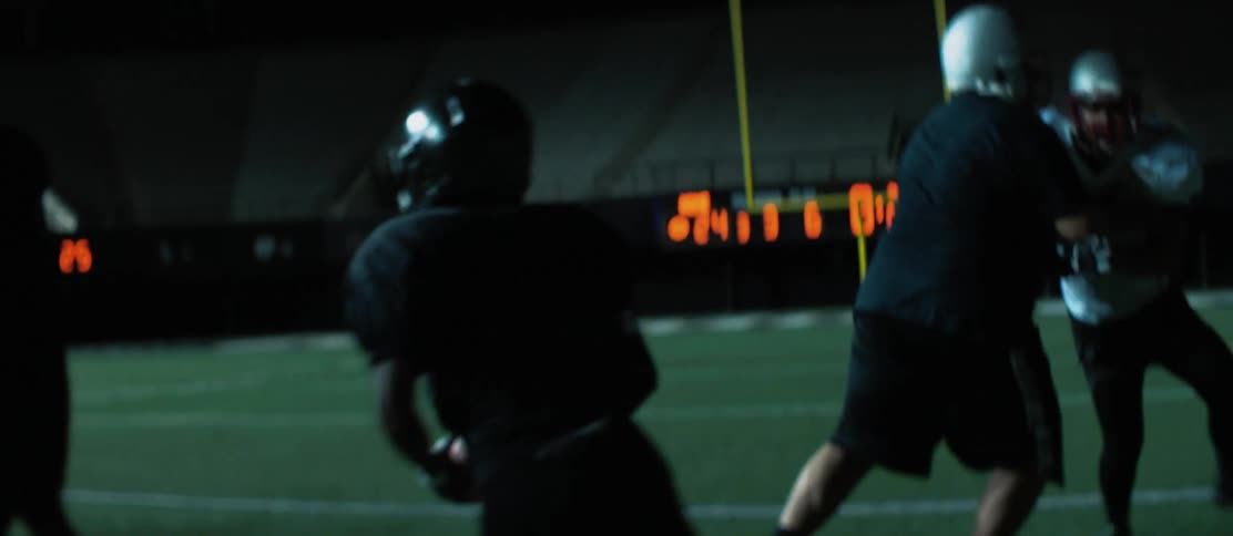 Teenagers playing football at a stadium