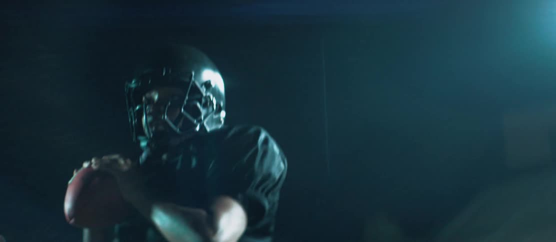 A teenager catches a football and then looks for someone to throw it to