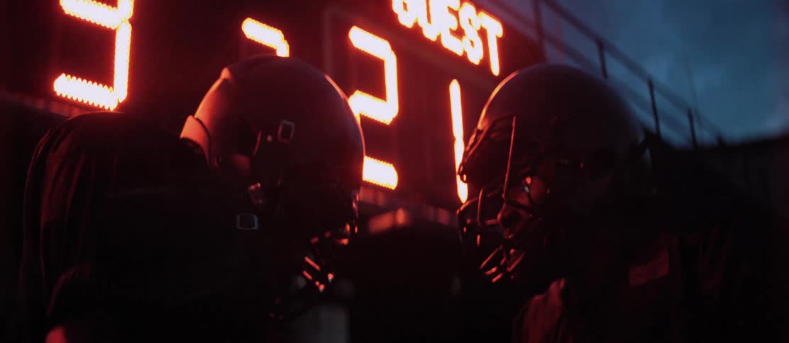 Two teenage football players do a handshake to prepare for a game