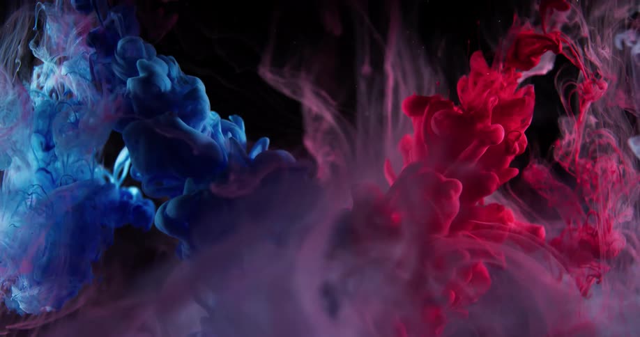 Red and blue substances spray into a clear liquid and mix causing purple clouds to rise up through the liquid