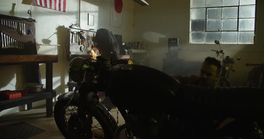 Mechanics work on motorcycles in a garage