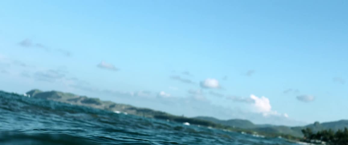 Choppy sea surface with a coast in the background