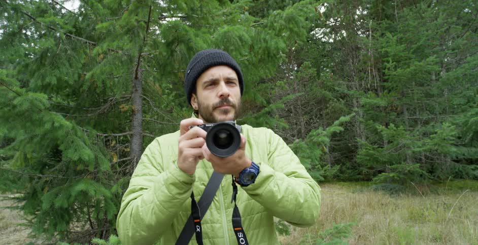 Photographer uses a camera in a forest