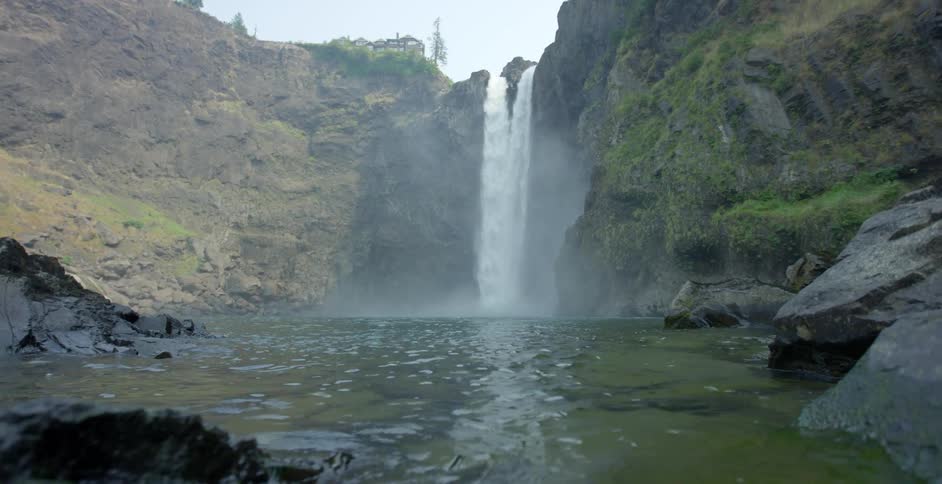 The waterfall pours into the stream below