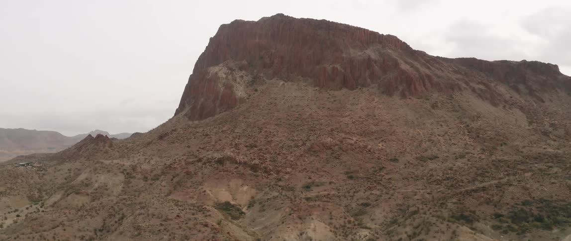 A mountain looms over a desert environment