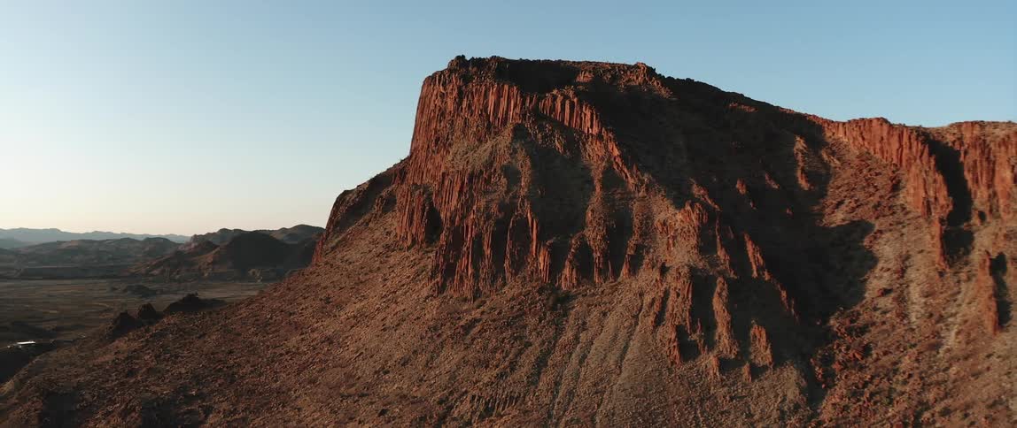 A brown arid mountain in the badlands during the day