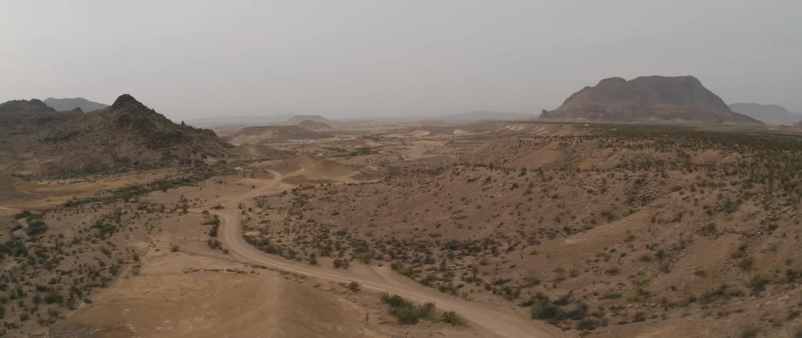 Road goes through the desert towards the mountains
