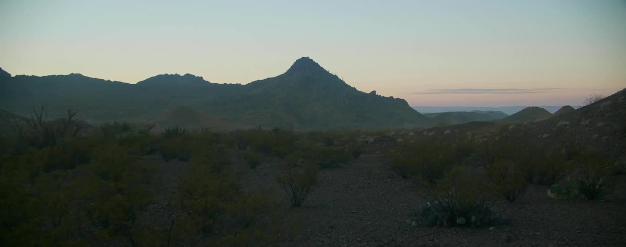 A landscape is displayed at sunset