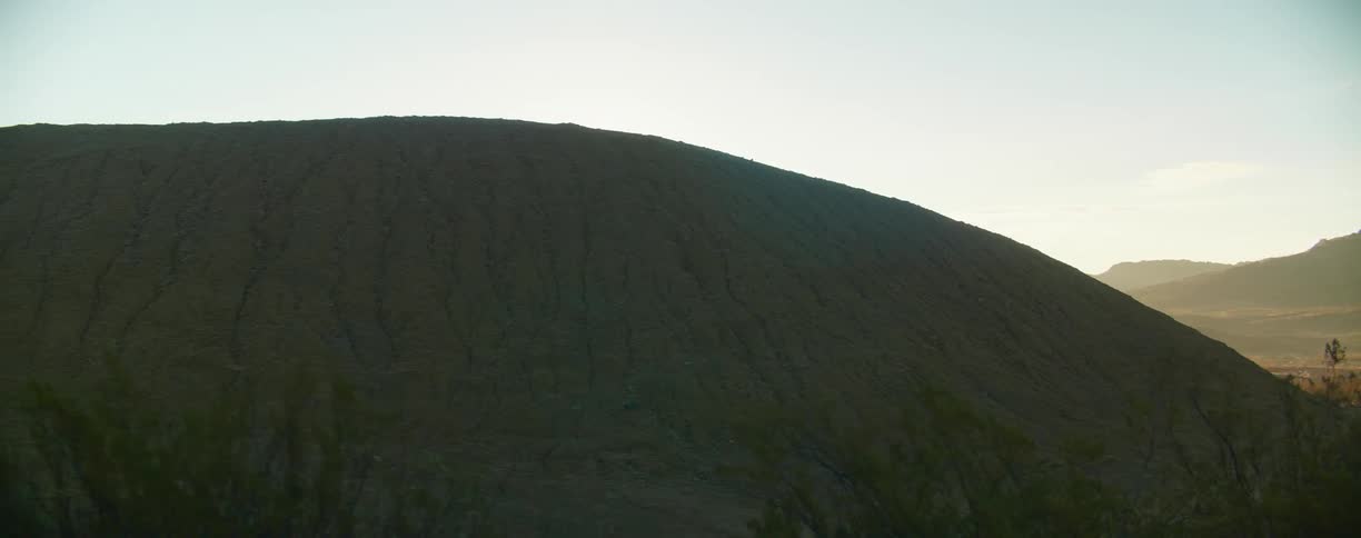 A hill sits near a valley in a desert
