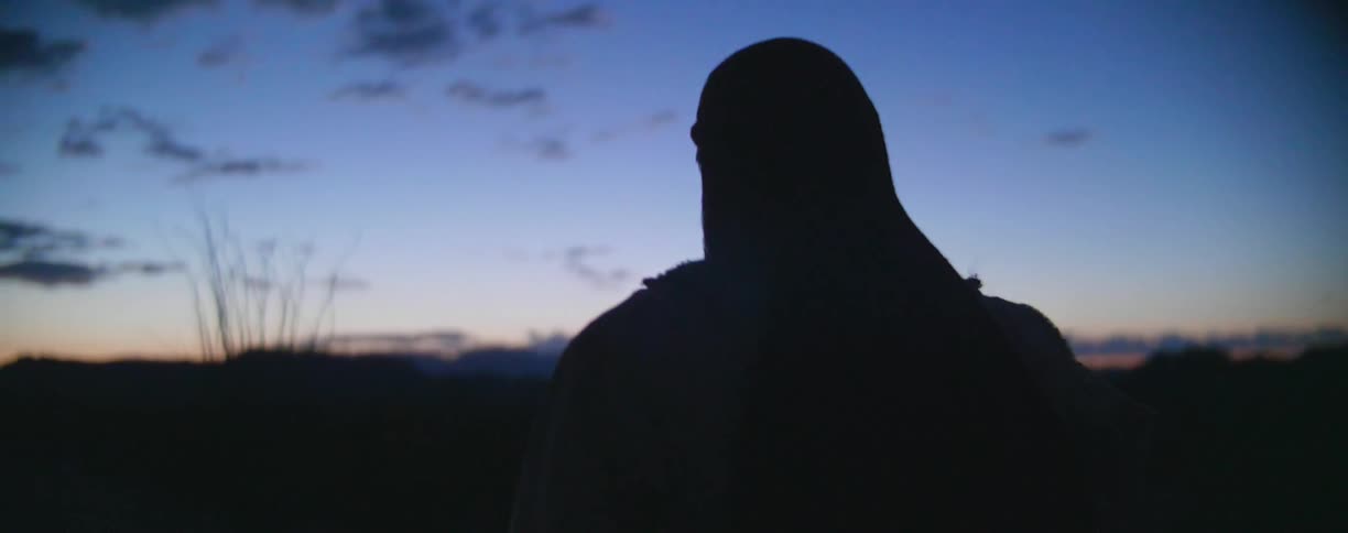 A man hikes at dusk