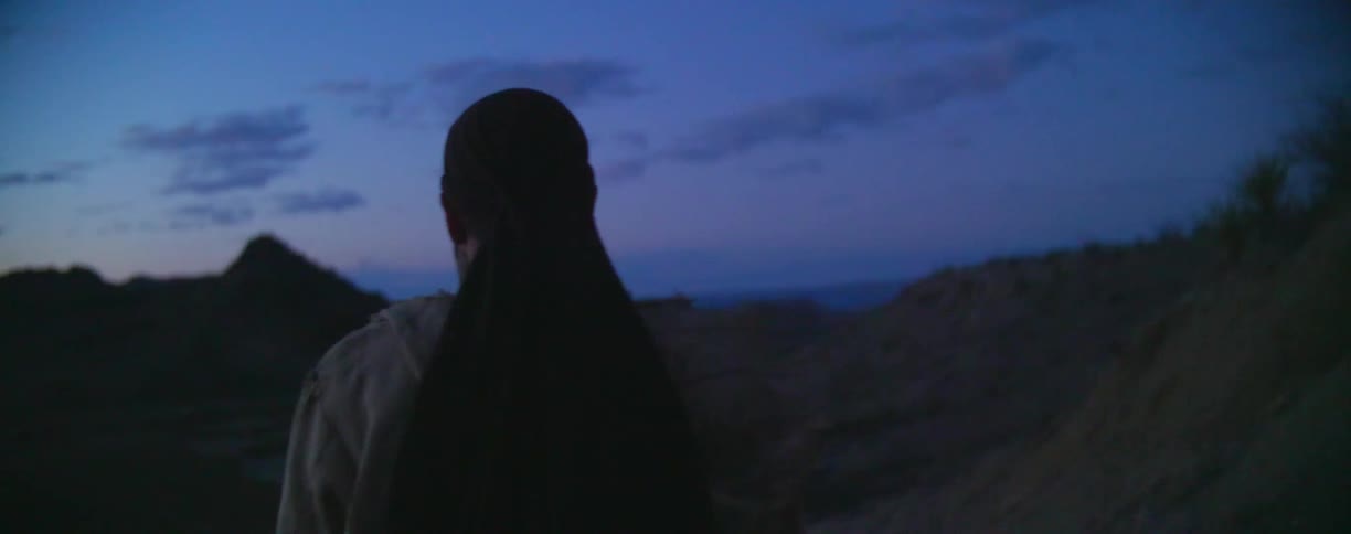 A man is hiking outside at sunset