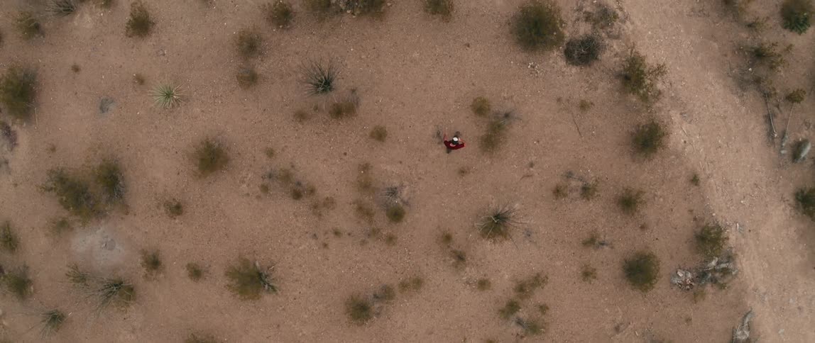 A man strides through a desert area