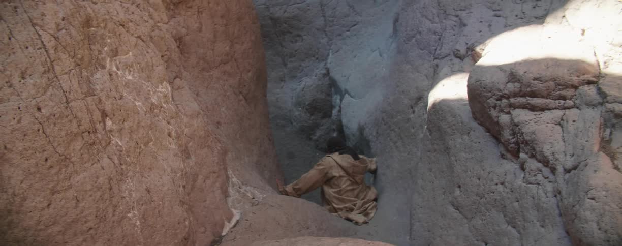 A man climbs down a canyon