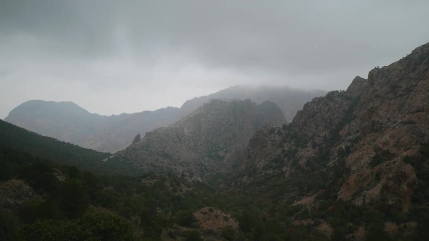 Rain clouds hover over a mountain valley