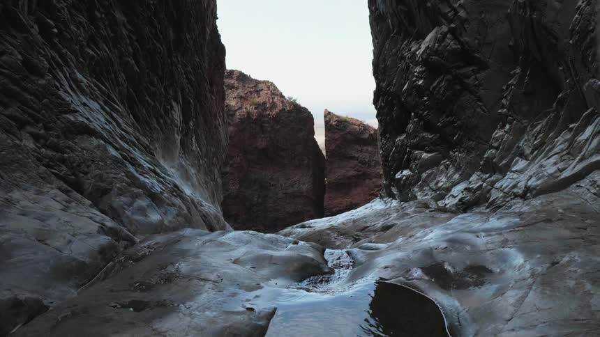 The water streams out of the cave