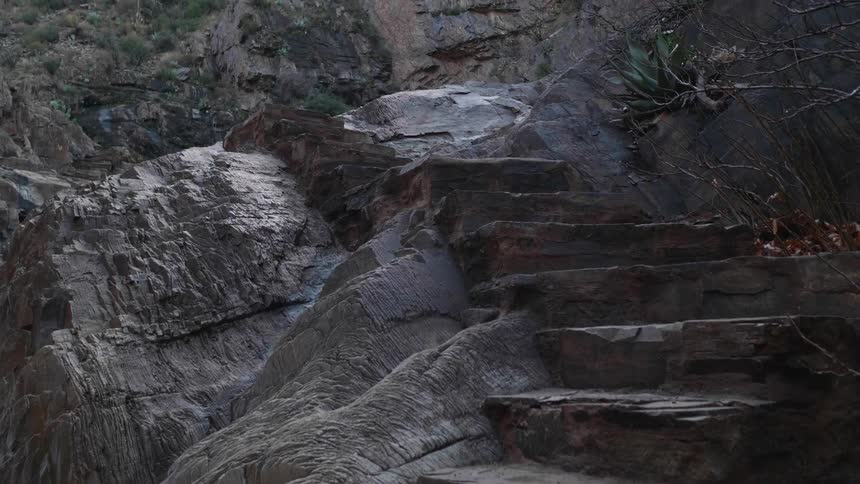 Stone stairs run up the side of a rock formation near a mountain