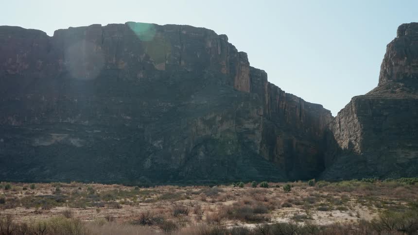 Mountains loom over a flat desert terrain