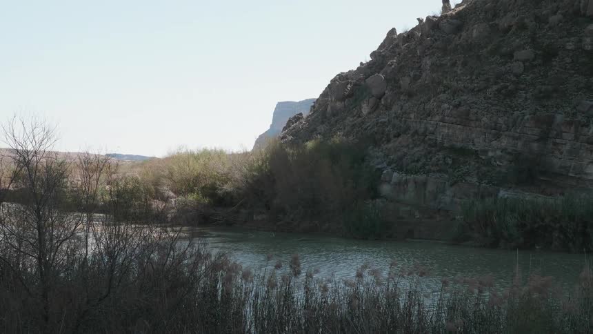 Calm waters of a river flow through the mountains in the badlands desert