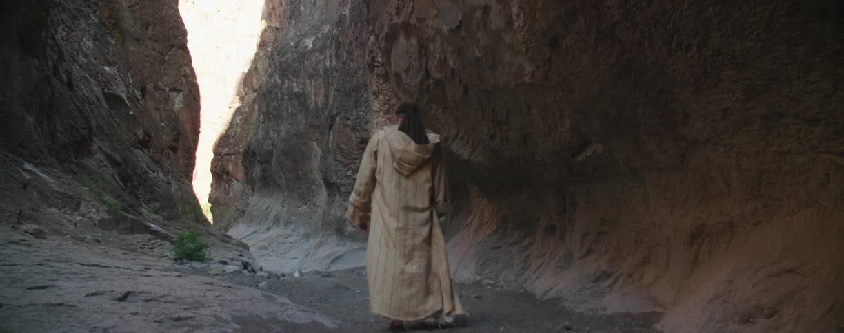A man walks through the narrow canyon
