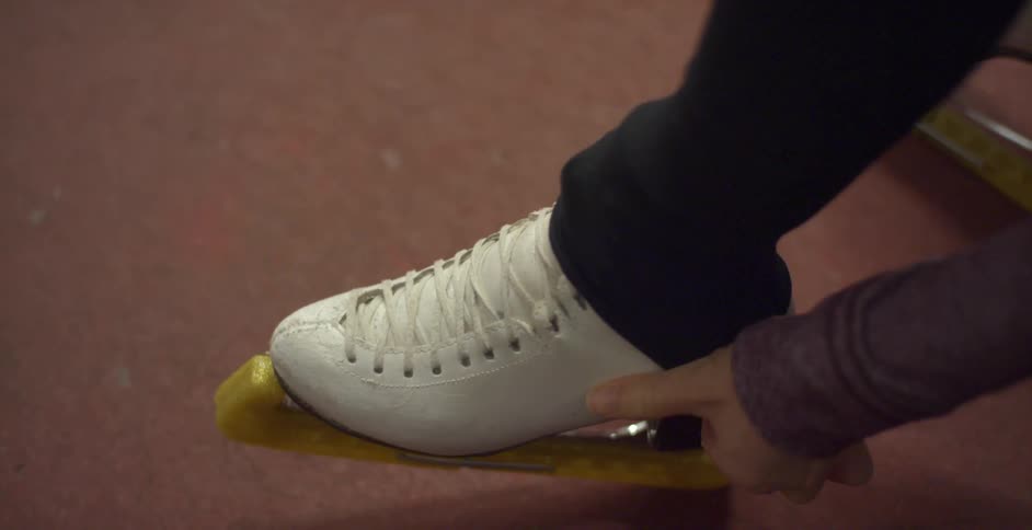 A woman pulls her pants down over the top of her skate
