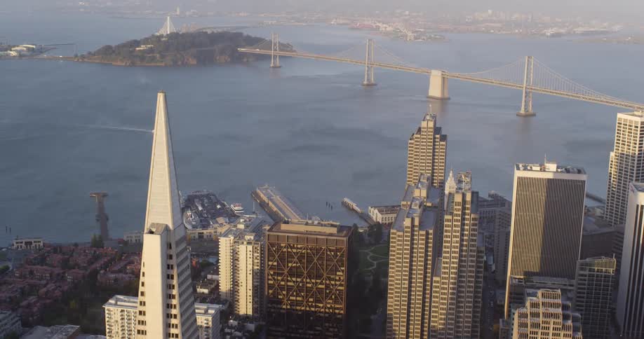 A view of a downtown city is displayed by an ocean