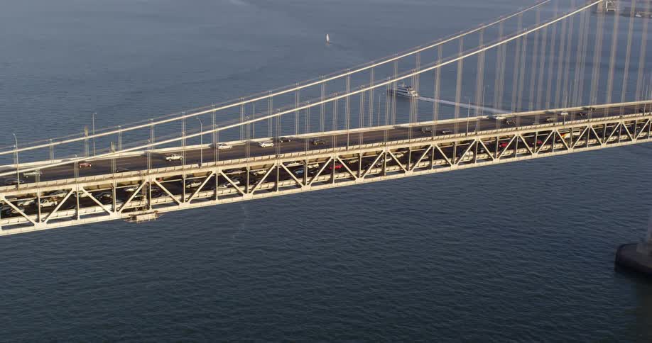 Aerial view of vehicles crossing a suspension bridge whose cables hang from towers that are attached to caissons or cofferdams