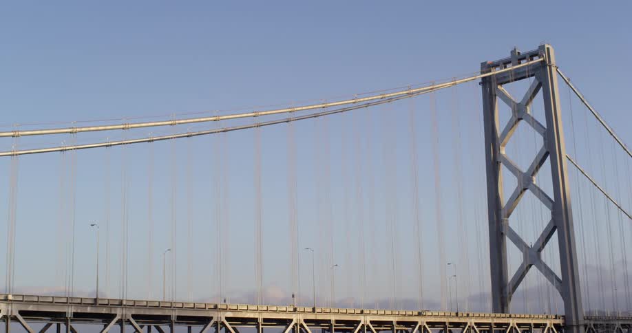 A suspension bridge stretches toward a city