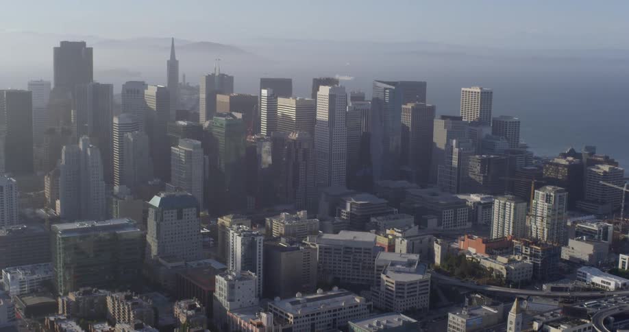 Haze obscures downtown skyscrapers as boats leave wakes in nearby water