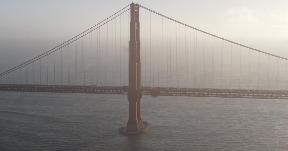 Fog shrouds bridge and horizon as traffic flows