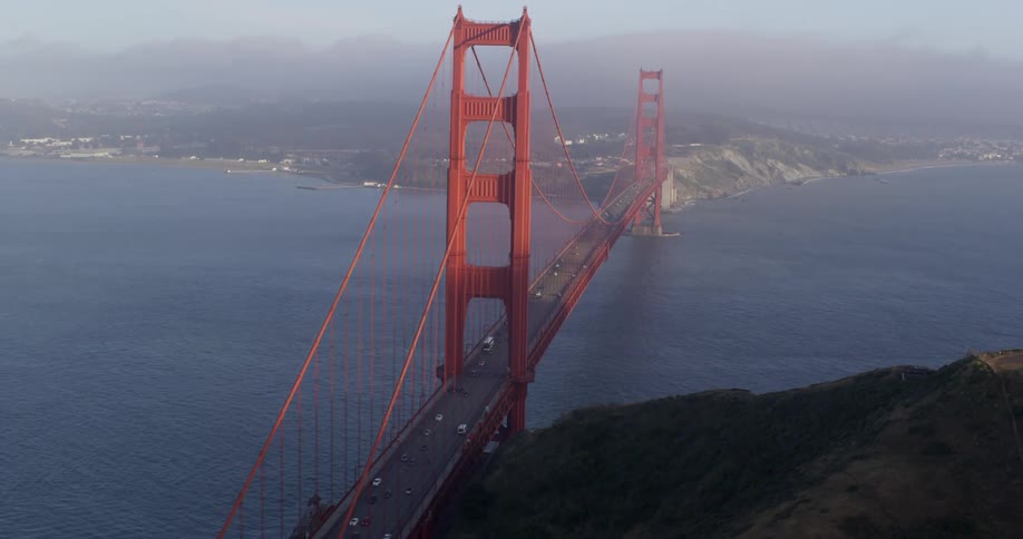 The golden gate bridge spanning a straight between two landmasses during the day