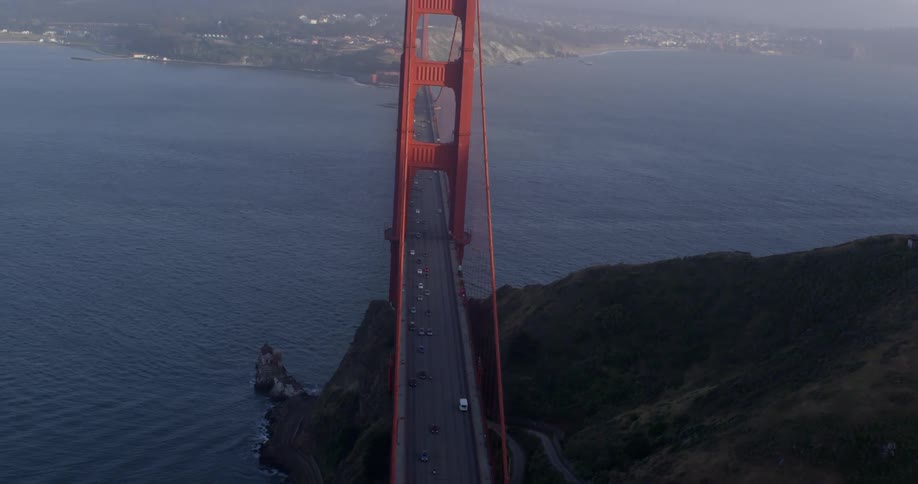 Cars are driving on a bridge above the ocean