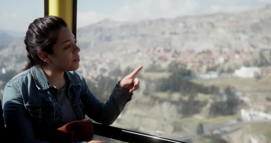 Couple ride a suspended cable car at day