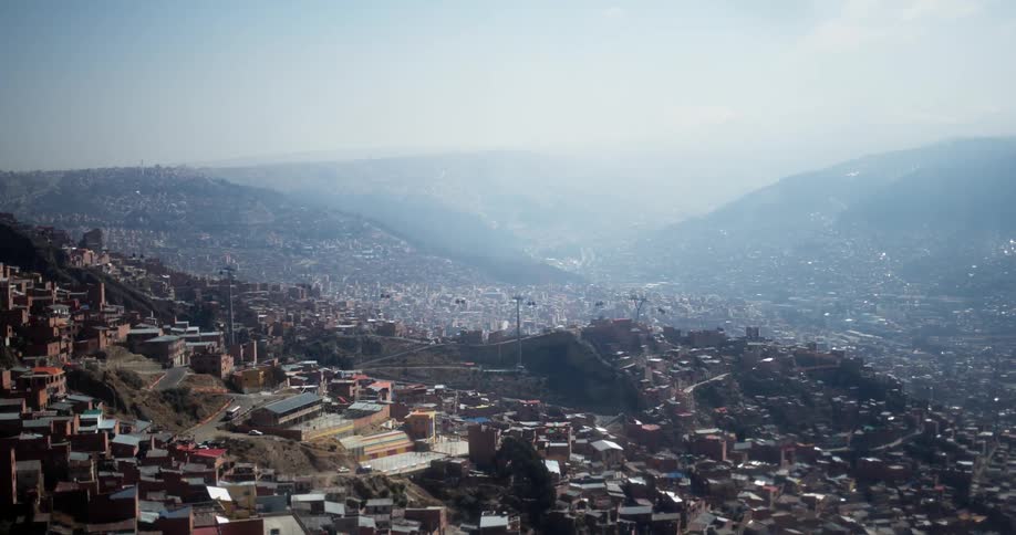 A view from aboard a cable car as it descends into a valley filled with homes