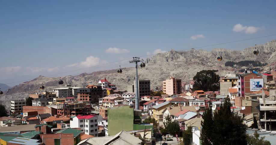 Cable car going up and down the line over a city at day