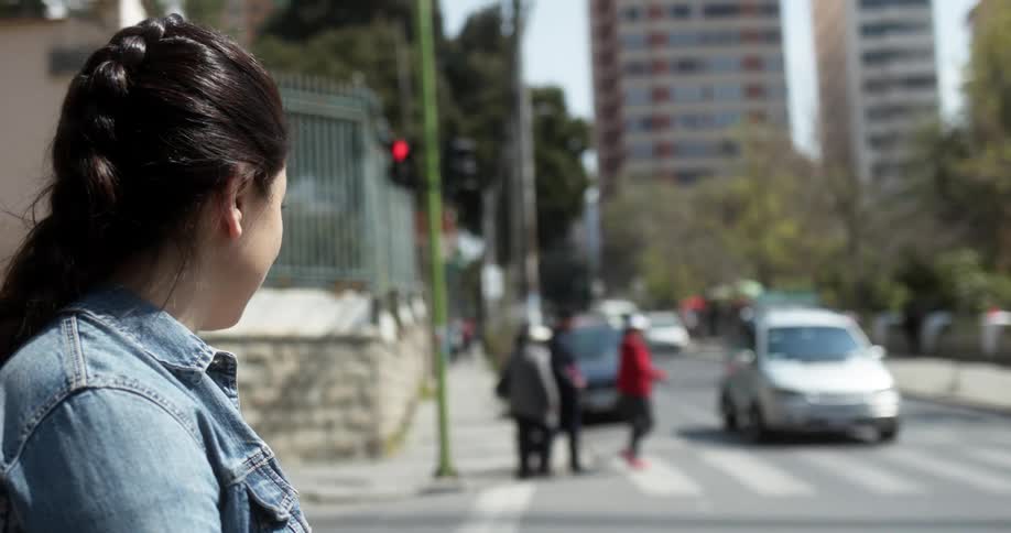 A girl waits to cross the busy intersection